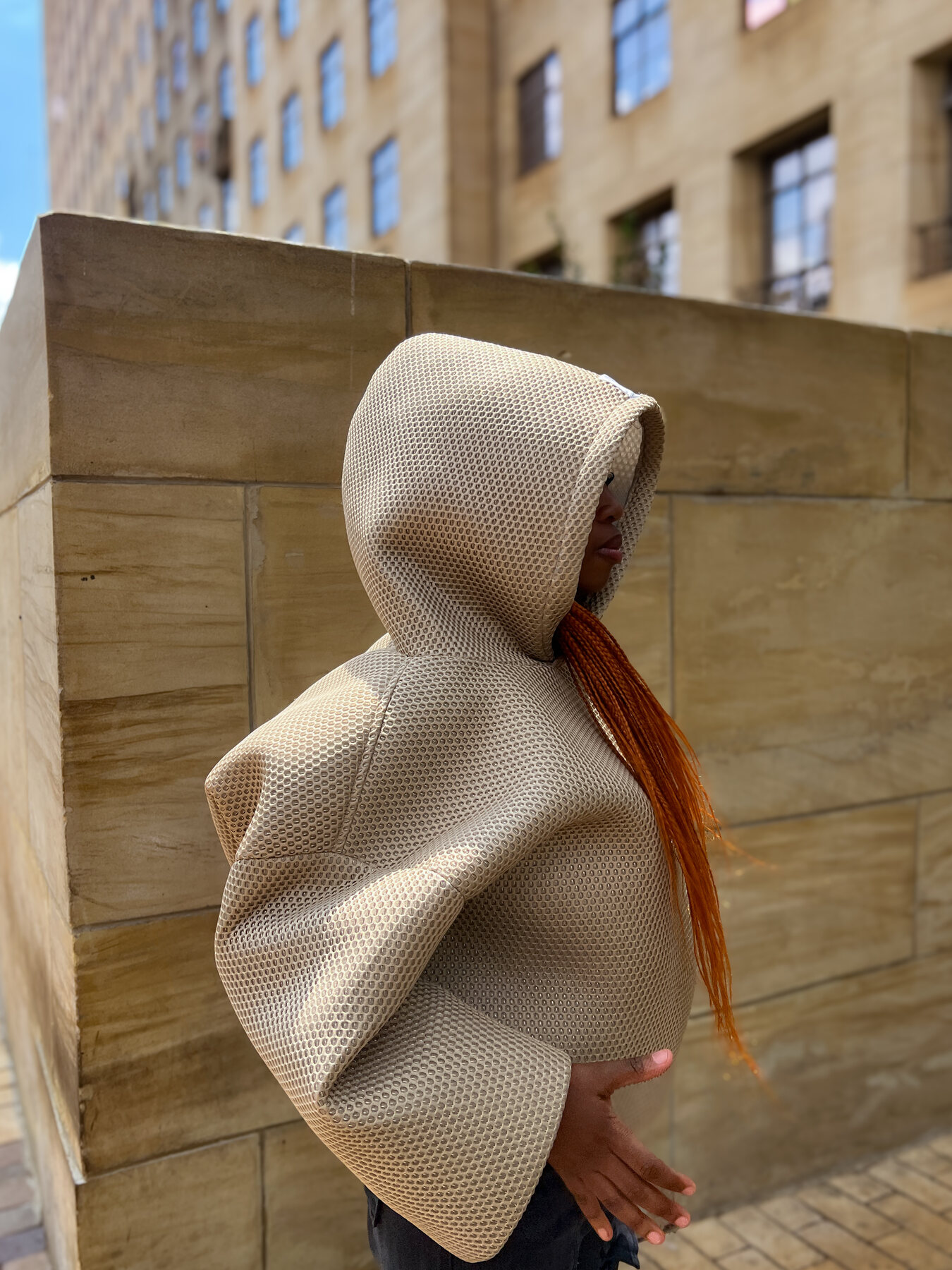 AMOR model in a light hooded outfit